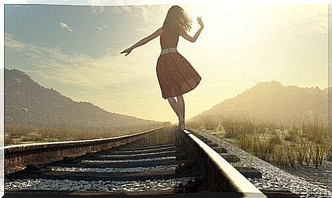 Girl walks along railway tracks