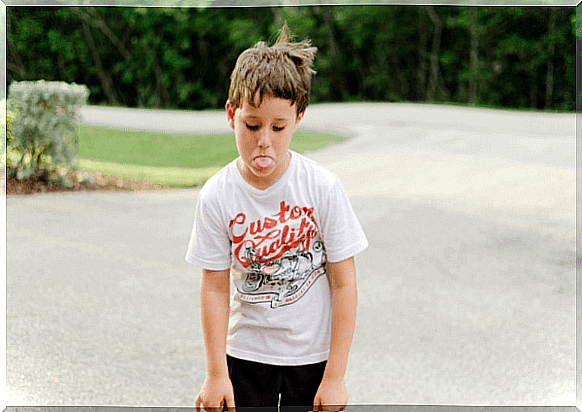 A little boy sticks out his tongue.