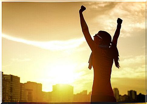 Woman on a run stretching her arms in the air