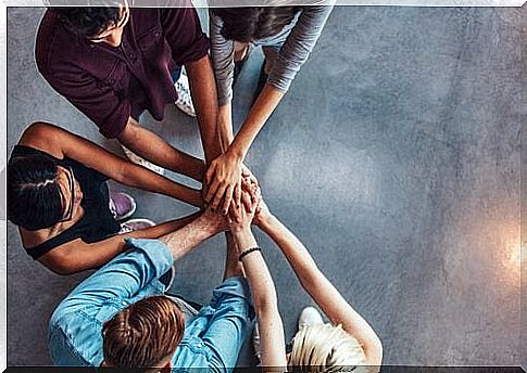 Colleagues gather hands.