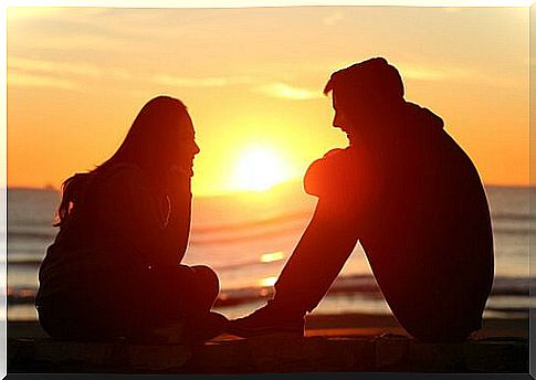 Two friends talking and listening at sunset.