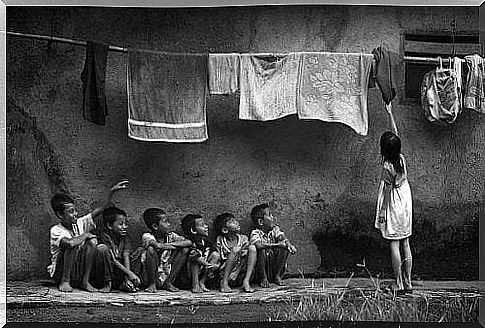 Boys watching the girl collect clean clothes.